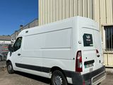 la camionnette blanche est garée devant un bâtiment dans un parking