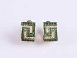 pair of emerald and diamond earrings on a white surface