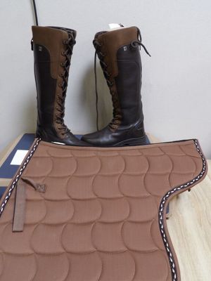a pair of boots and a saddle pad on a table