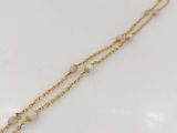 a gold chain bracelet with pearls and a pearl bead
