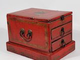 a small red box with three drawers on it
