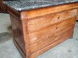a wooden chest with a marble top in the middle of a room