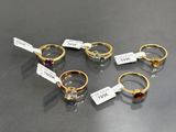 six different rings with tags on them sitting on a table