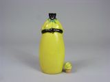 a figurine of a woman in a yellow dress with a black cat on her shoulder