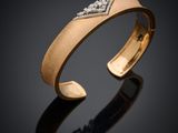 un gros plan sur un bracelet en or serti de diamants