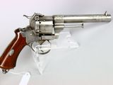 un vieux revolver avec une poignée en bois sur une surface blanche