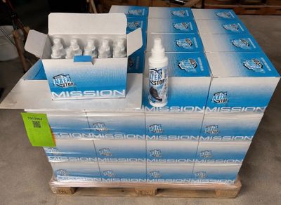 des cartons d'eau « Mission » posés sur une palette dans un entrepôt