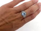 Quelqu'un tient une bague sertie d'une pierre bleue.