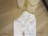 a white and yellow outfit on the floor next to a couch