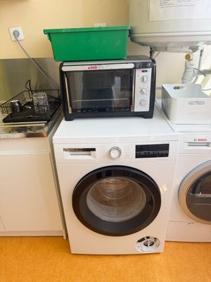 a microwave and a washing machine in a kitchen