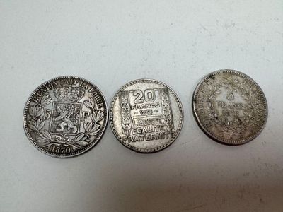 three silver coins sitting on top of a table next to each other