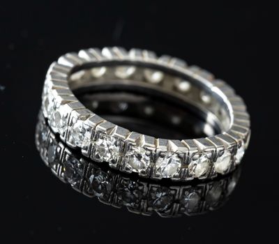 a close up of a diamond ring on a black surface