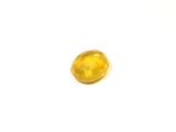 a close up of a yellow diamond on a white surface
