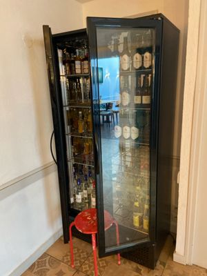 a glass case with bottles in it in a room