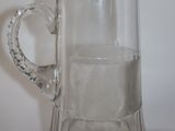 un pichet en verre transparent orné d'un bord doré