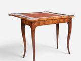 a wooden table with a red leather top and legs