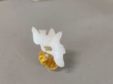 a small white flower sitting on a table next to a yellow vase