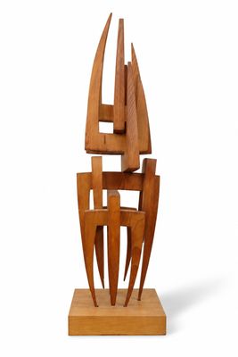 wooden sculpture of a sailboat on a wooden base on a white background