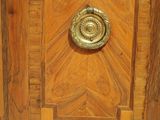 a small wooden cabinet with a brass knob on it