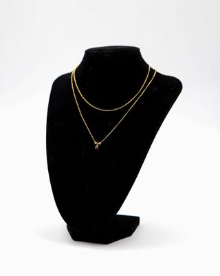 un mannequin noir portant un collier en or