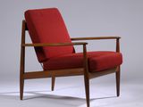 une chaise rouge avec une structure en bois et des accoudoirs