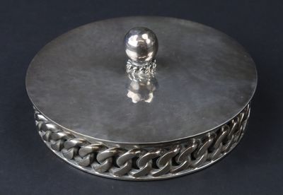 une boîte en argent sur laquelle trône une figurine en argent