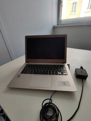 a laptop that is sitting on a table with a charger