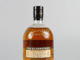 une bouteille de whisky single malt Glenmores posée sur une surface blanche