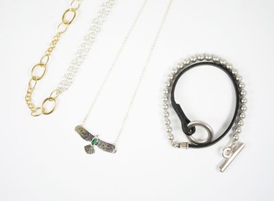 trois colliers et un bracelet posés sur une surface blanche