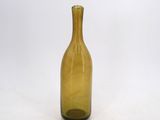 a yellow glass bottle sitting on a white surface