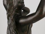 bronze statue of a woman holding a glass in her hand