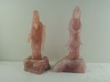 une paire de statues en quartzite rose représentant une femme et un homme, posées sur un rocher