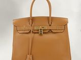 a brown leather handbag with a gold lock on the handle