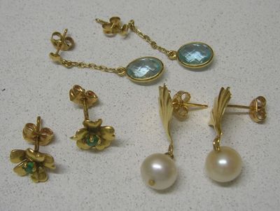 deux paires de boucles d'oreilles et une paire de boucles d'oreilles posées sur une table