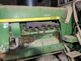 a green tractor that is sitting in a barn