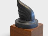 sculpture of a winged wing on a wooden base on a white background