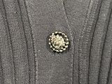 a close up of a sweater with a brooch on it