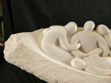 a white sculpture on a black surface with a black background