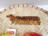 a small tortoise shaped comb and some fruit on a tray