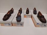 four pairs of brown shoes are on display in a display case