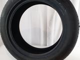 an image of a tire on a white surface with a curtain in the background