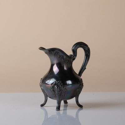 a black pitcher sitting on a white table