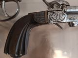 a gun and a revolver on display in a glass case