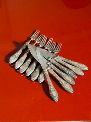 a bunch of forks and knives on a red table