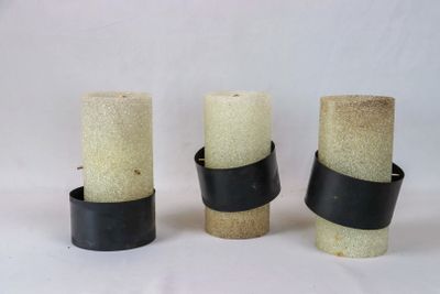 trois bougies sont alignées sur une surface blanche