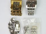 two watches and a bracelet are sitting next to each other