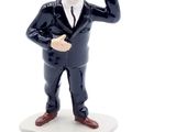 a figurine of a man in a tuxedo next to a hat