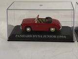 a small red car in a clear case on a table