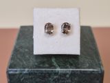 a pair of earrings sitting on top of a marble block
