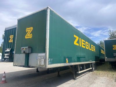 une semi-remorque verte garée sur le bord de la route
